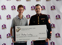  Boy and Member of the Marine Corps Stand Together holding a large symbolic check